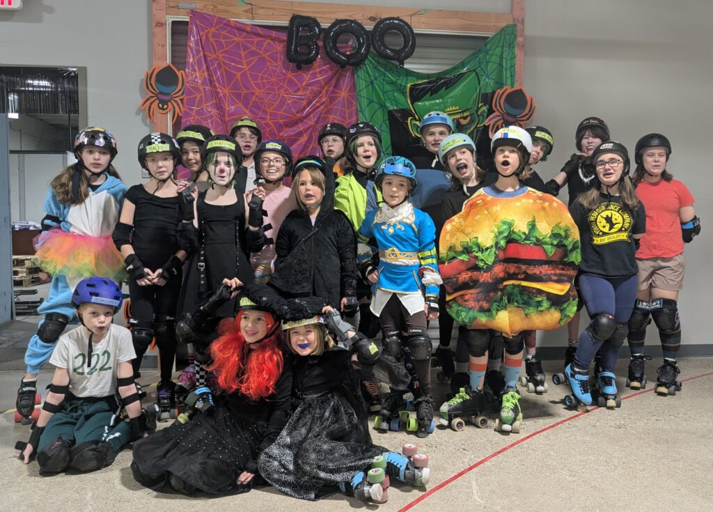 A group of young roller derby skaters in colorful Halloween costumes