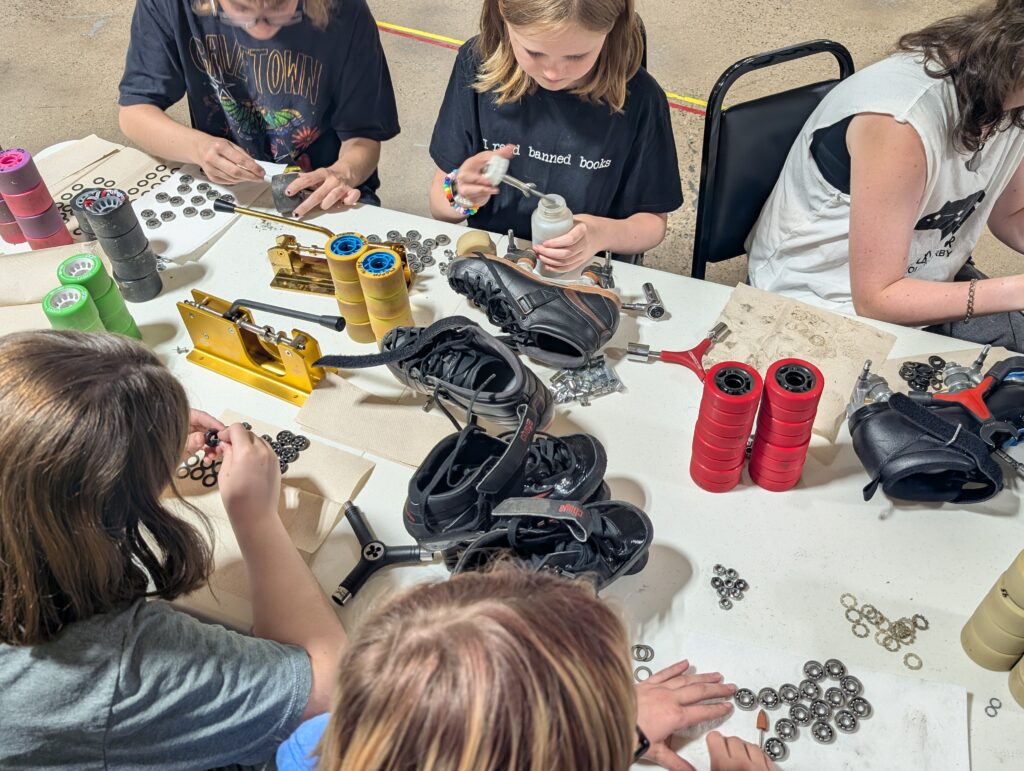 SKaters sitting around a table cleaning wheel bearings.